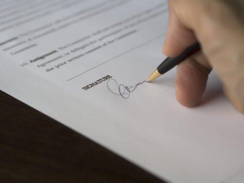 Person signing a professional contract document