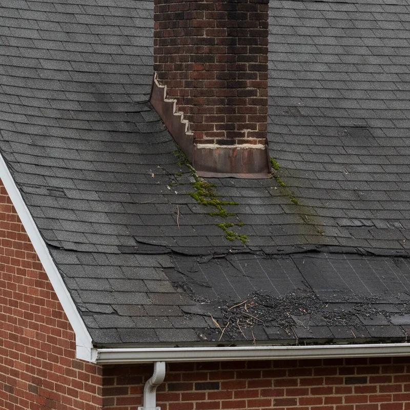 A row of aging Philadelphia row homes in Kensington with visibly worn flat roofs and patched membranes on a cloudy day