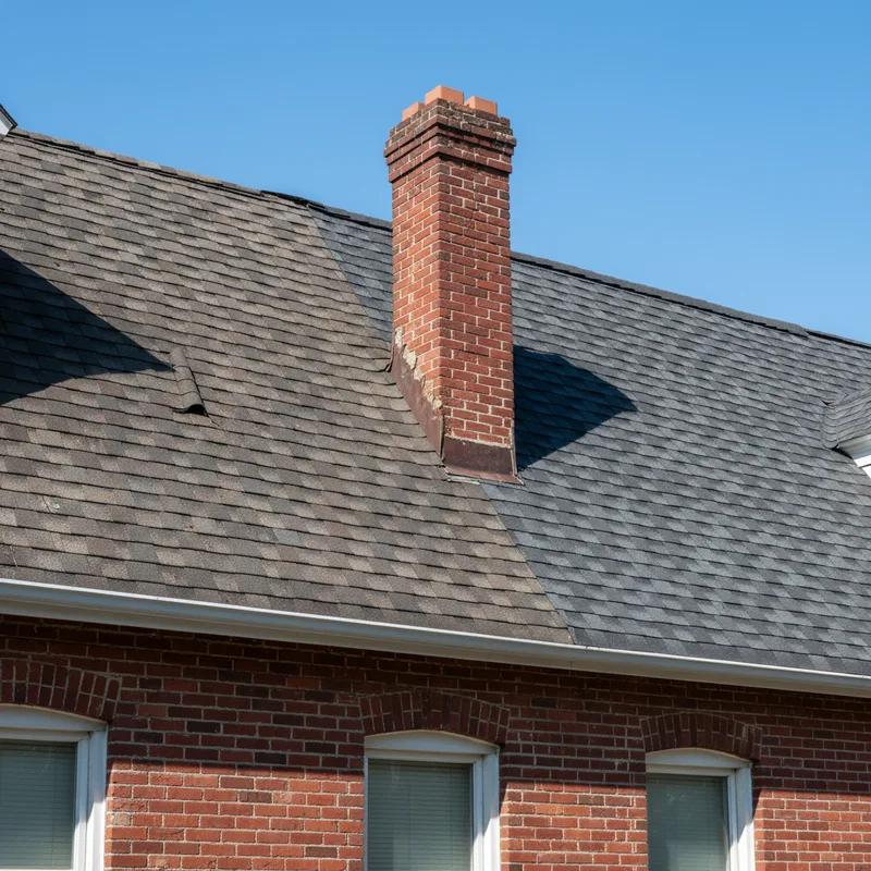 A Philadelphia homeowner reviewing a roofing estimate on a clipboard while standing in front of their brick row home in South Philadelphia